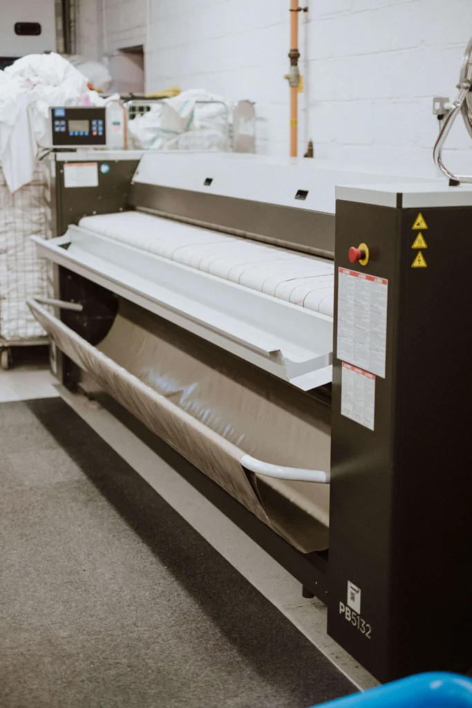 Hotel bed linen being pressed on the ironer at the Southampton facility
